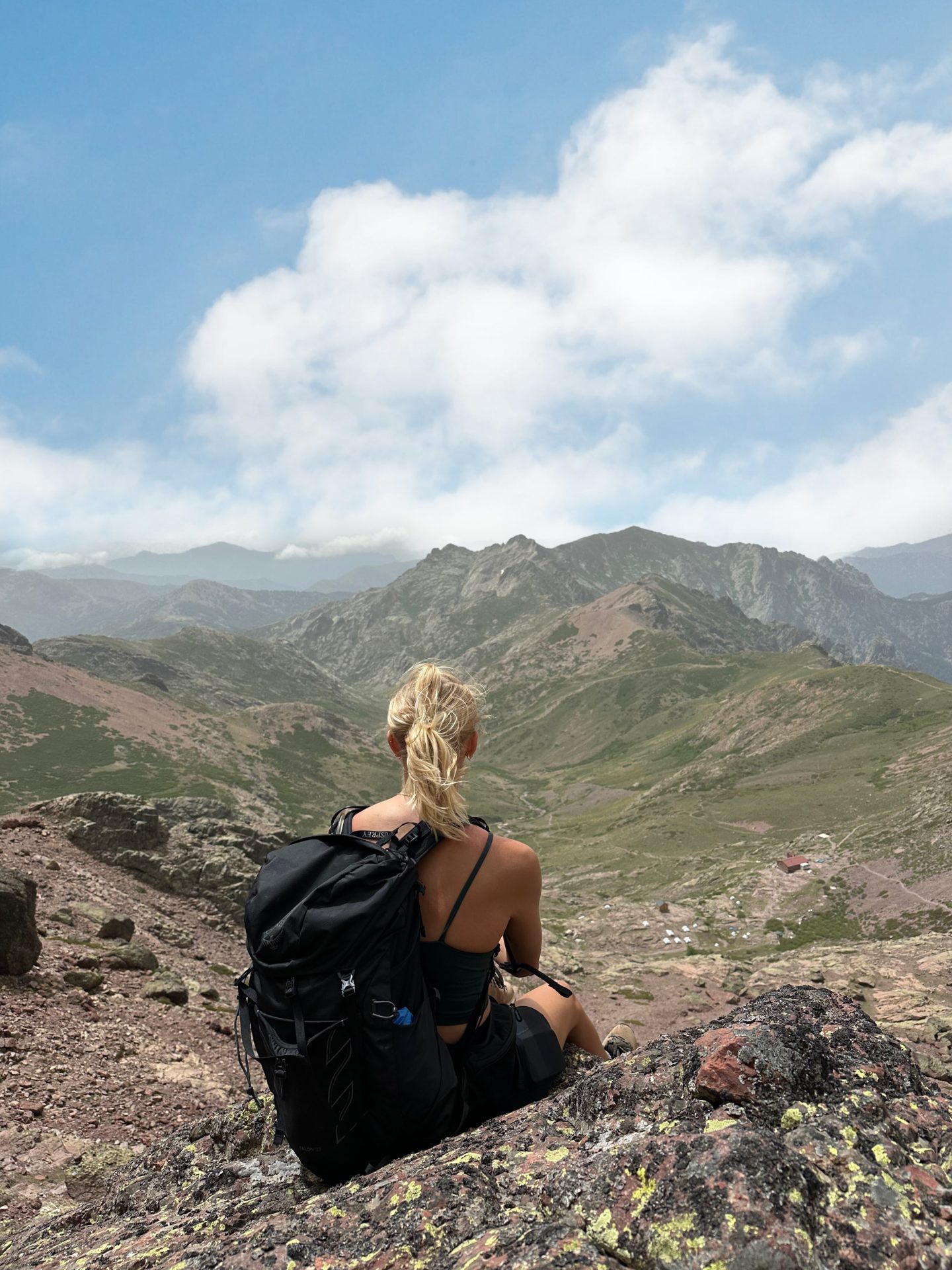 Zanna van Dijk sits atop a mountain in Corsica looking out across a mountain range