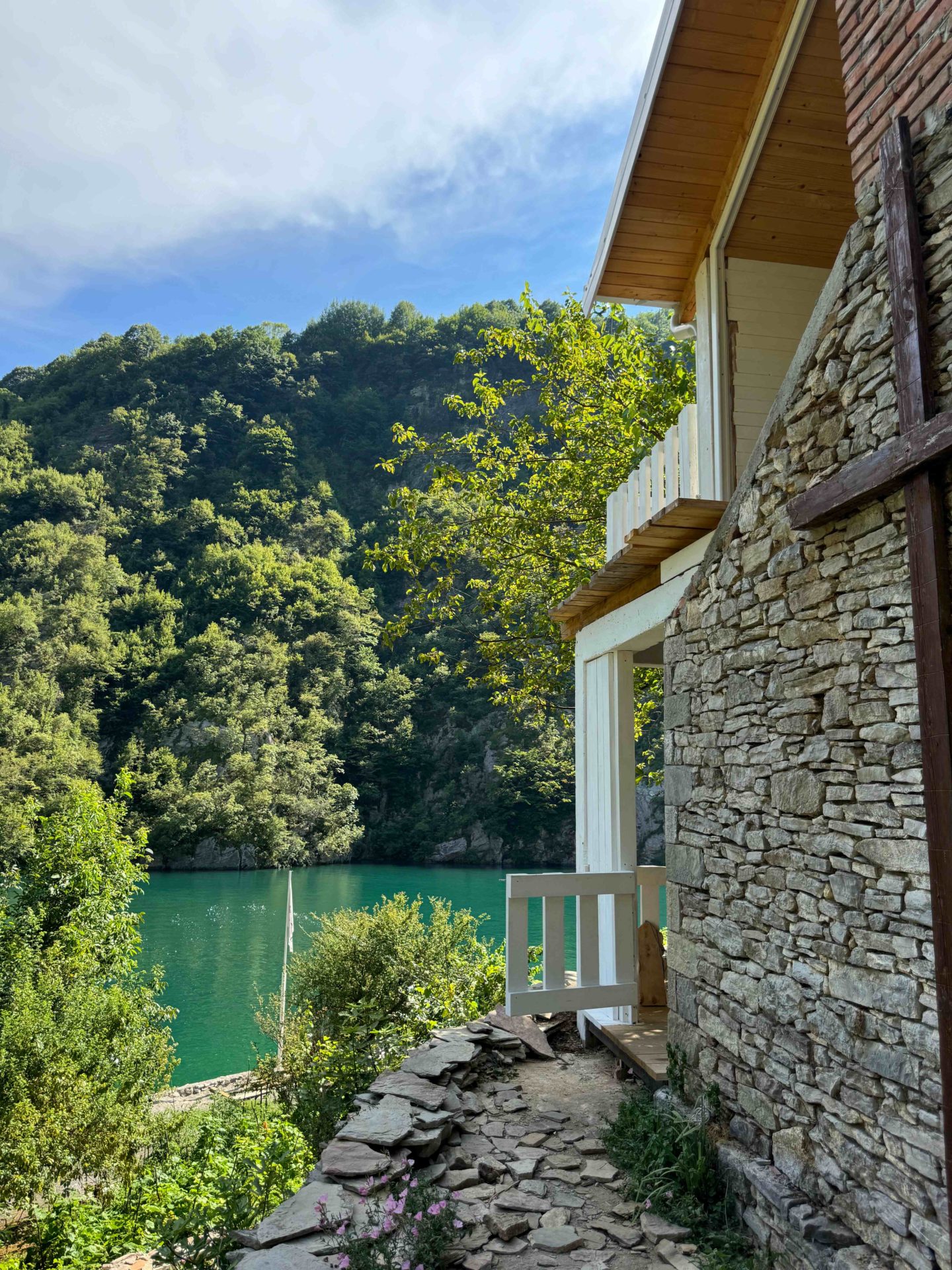 A house sitting on the water's edge at Komani Lake in Albania