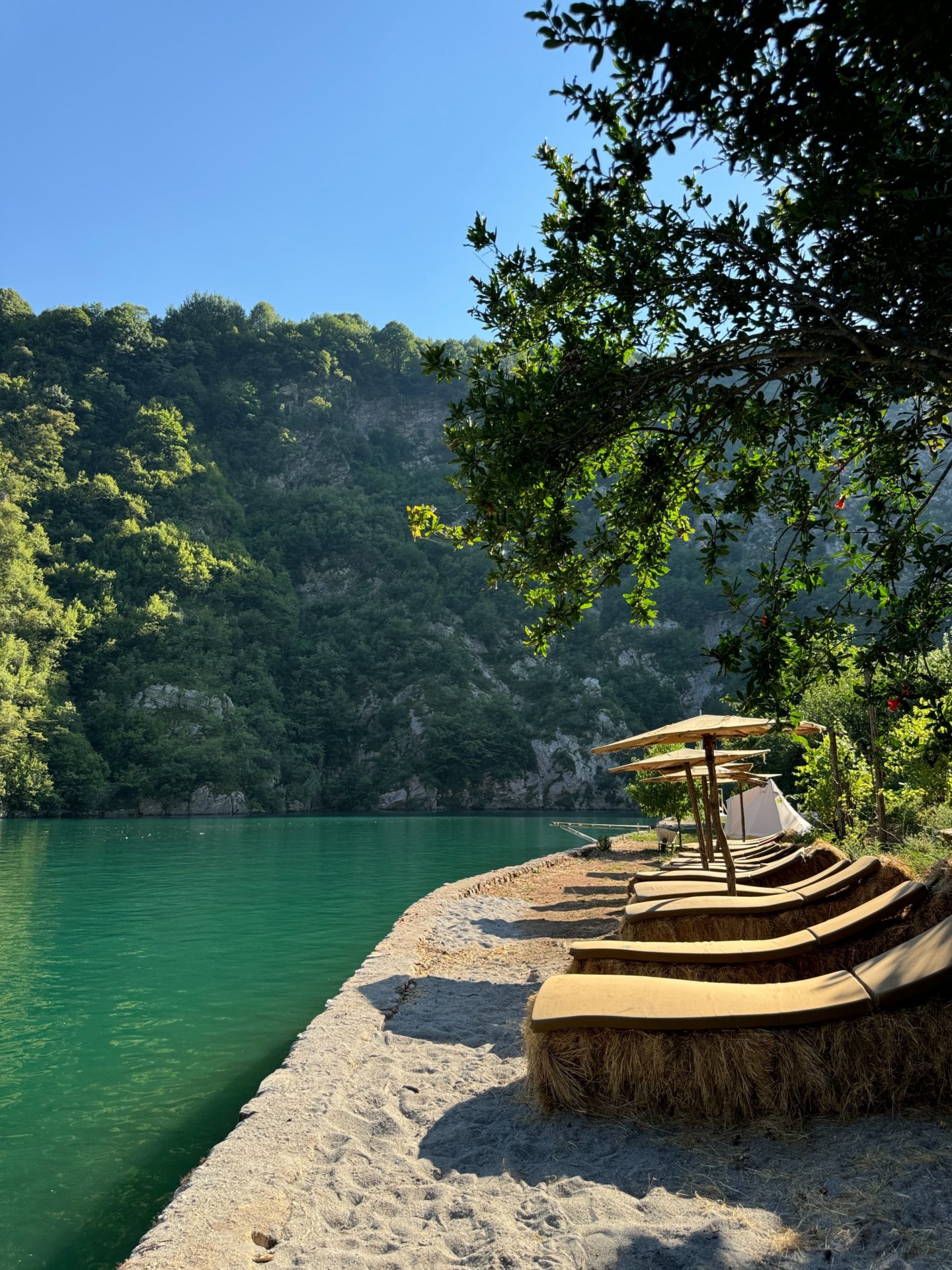 Sunbeds lining the edge of Komani Lake in Albania